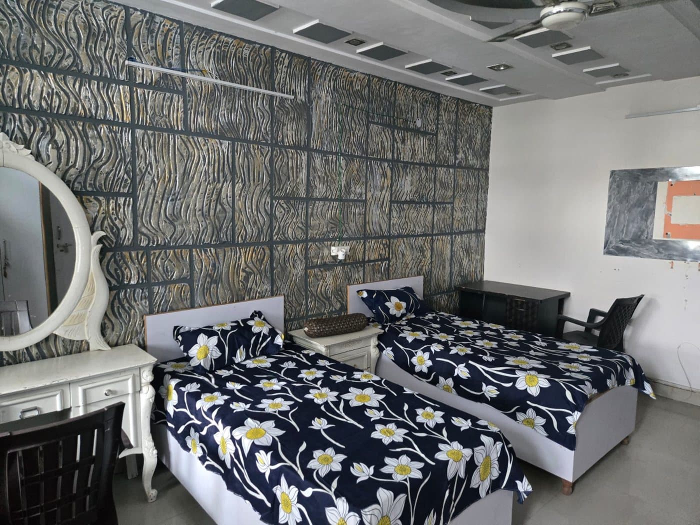 Double-sharing room with two beds and a dressing mirror